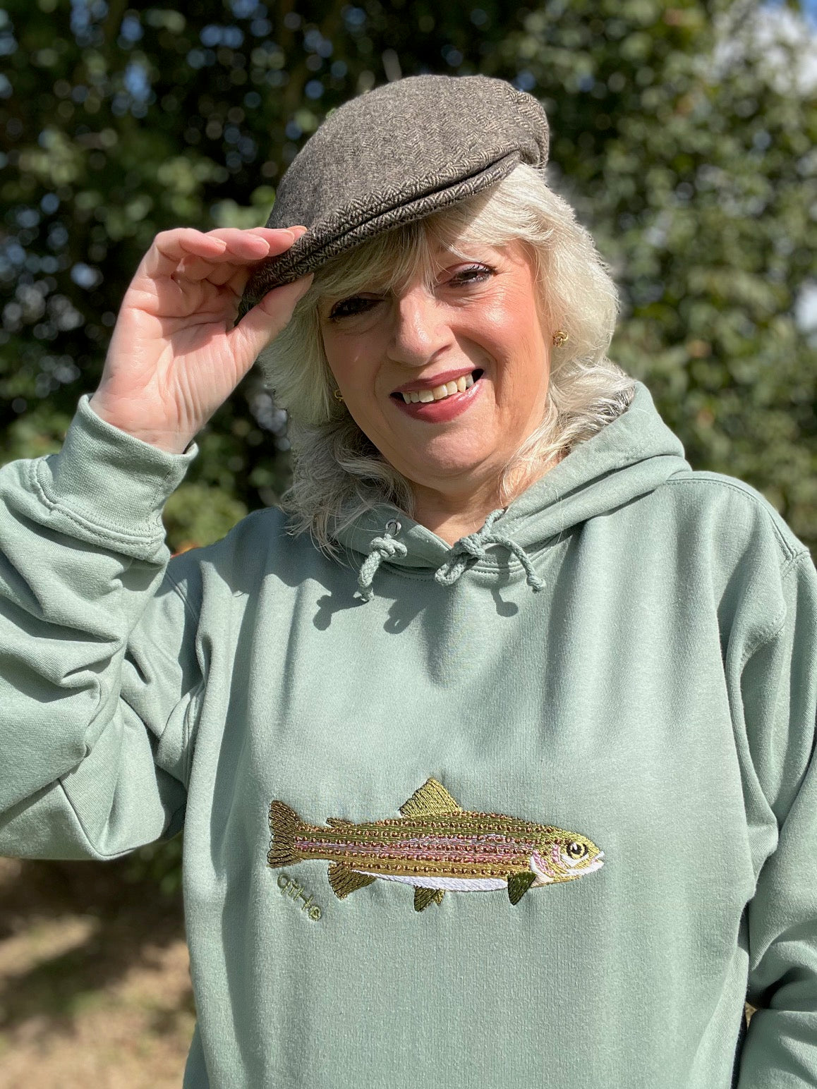 Model wearing the Heritage Earth Rainbow Trout embroidered hoodie